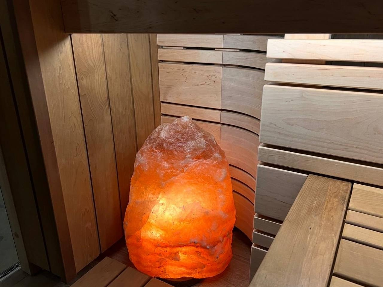 Парная в Родных Просторах выполнена по индивидуальному проекту. В потолке красуется можжевеловое панно, а в углу- глыба из гиммалайской соли. SaunaTopMasters