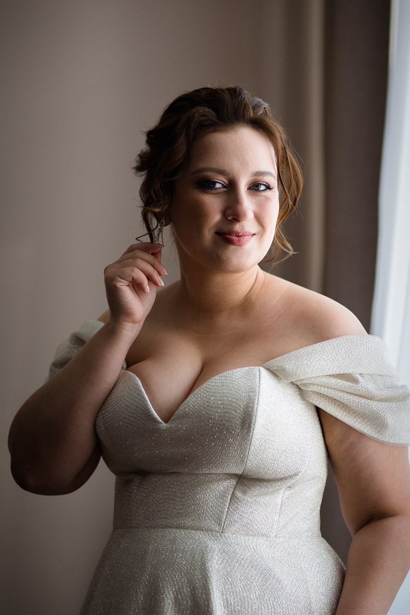 Невеста у окна смотрит в кадр