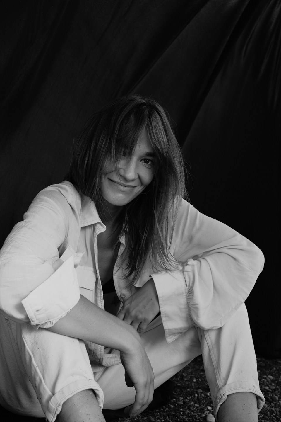 Изображение девушки которая сидит на полу на фоне черный фотофон