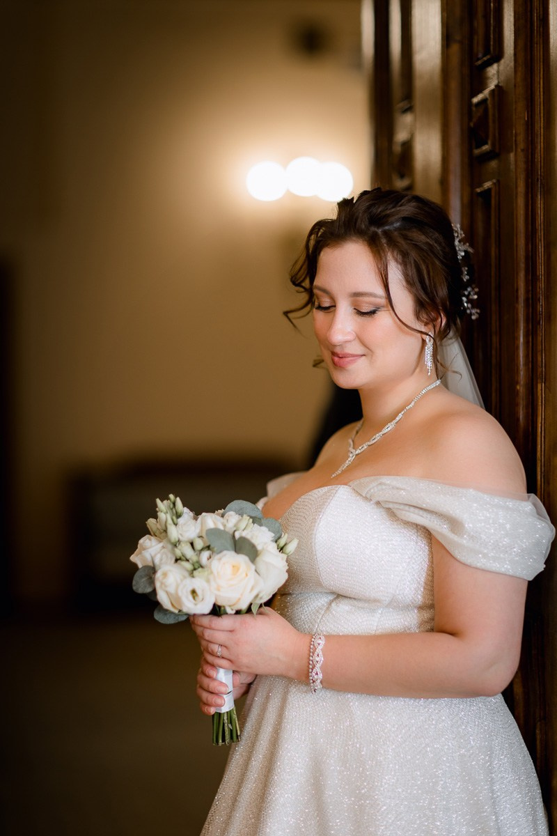 Невеста смотрит на букет в интерьере в ЗАГСе на фурштатской СПб.