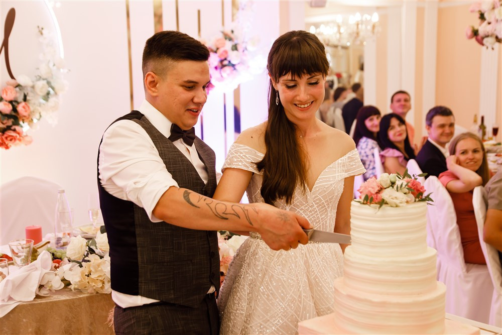 Жених и невеста разрезают свадебный т орт.