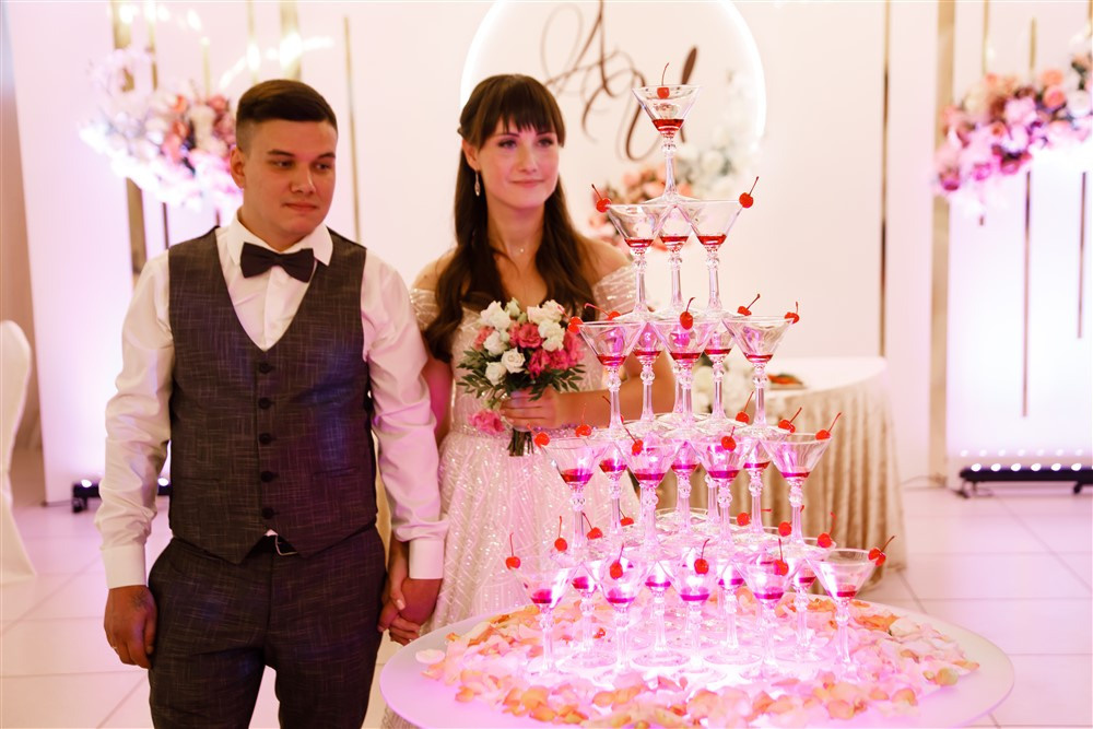 Жених и невеста у пирамиды шампанского