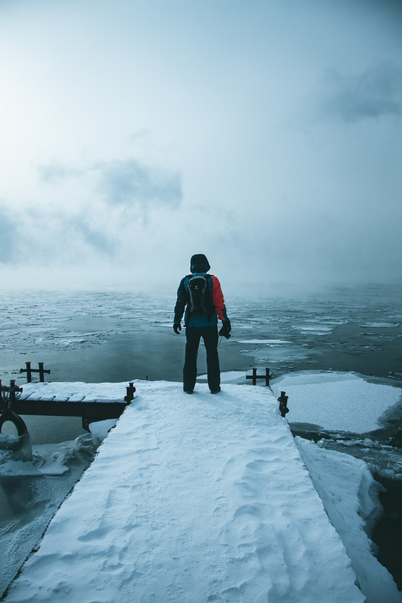 Мужчина на пирсе смотрит на озеро Байкал