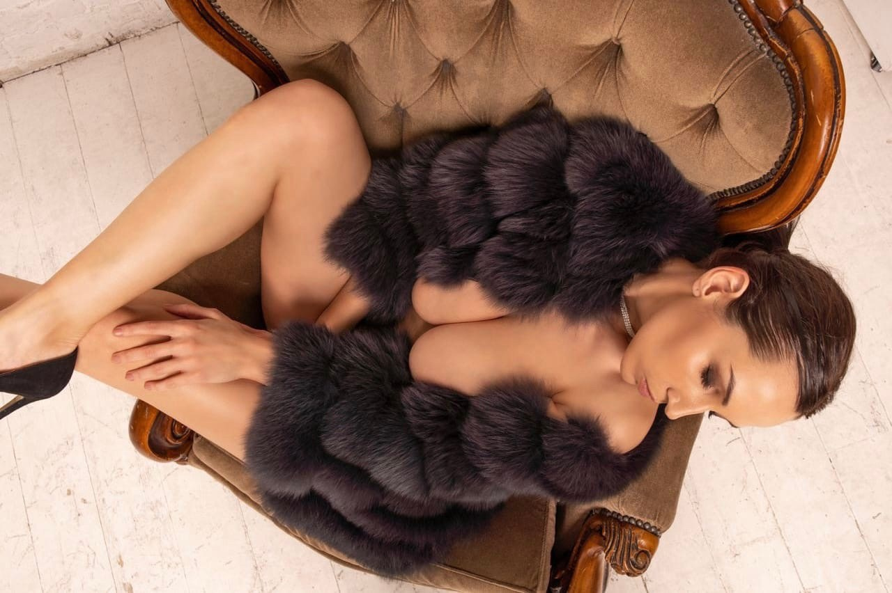модель в шубе на голое тело лежит на кресте