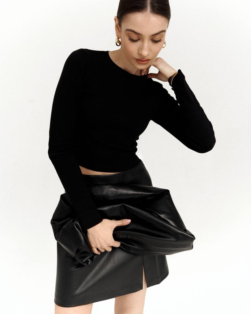 Саша на модельных тестах — чёрный топ и кожаная юбка, белый фон