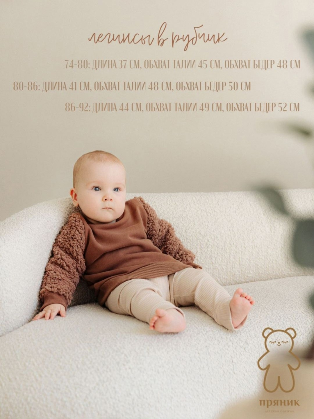 Малыш в коричневой кофте сидит на диване