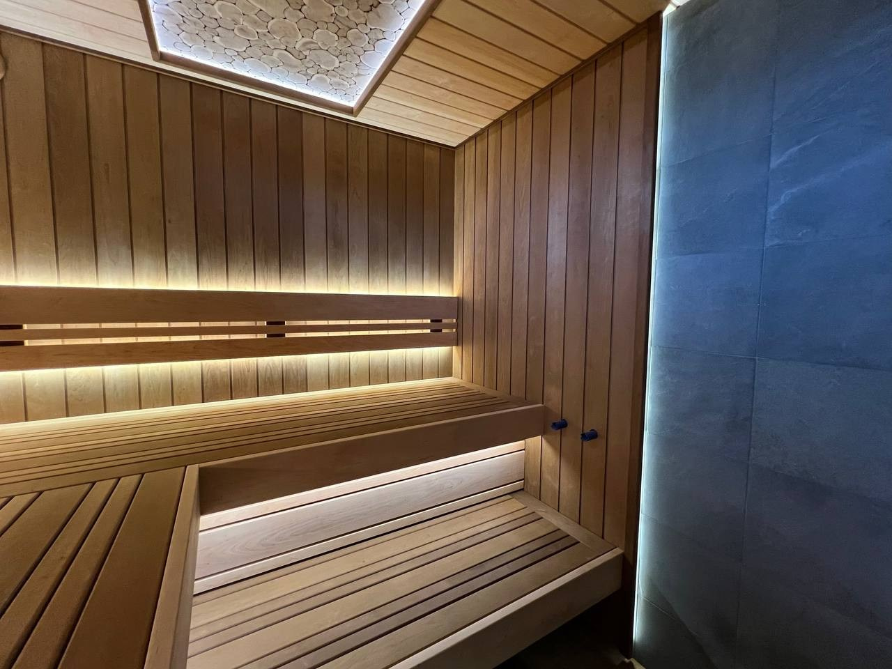 Парная в Родных Просторах выполнена по индивидуальному проекту. В потолке красуется можжевеловое панно, а в углу- глыба из гиммалайской соли. SaunaTopMasters