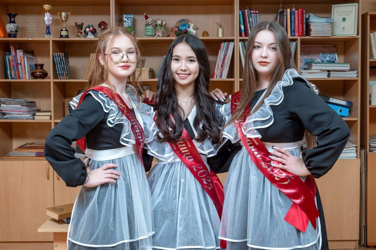 Подруги одноклассницы стильно позируют фотографу в классе любимой школы.