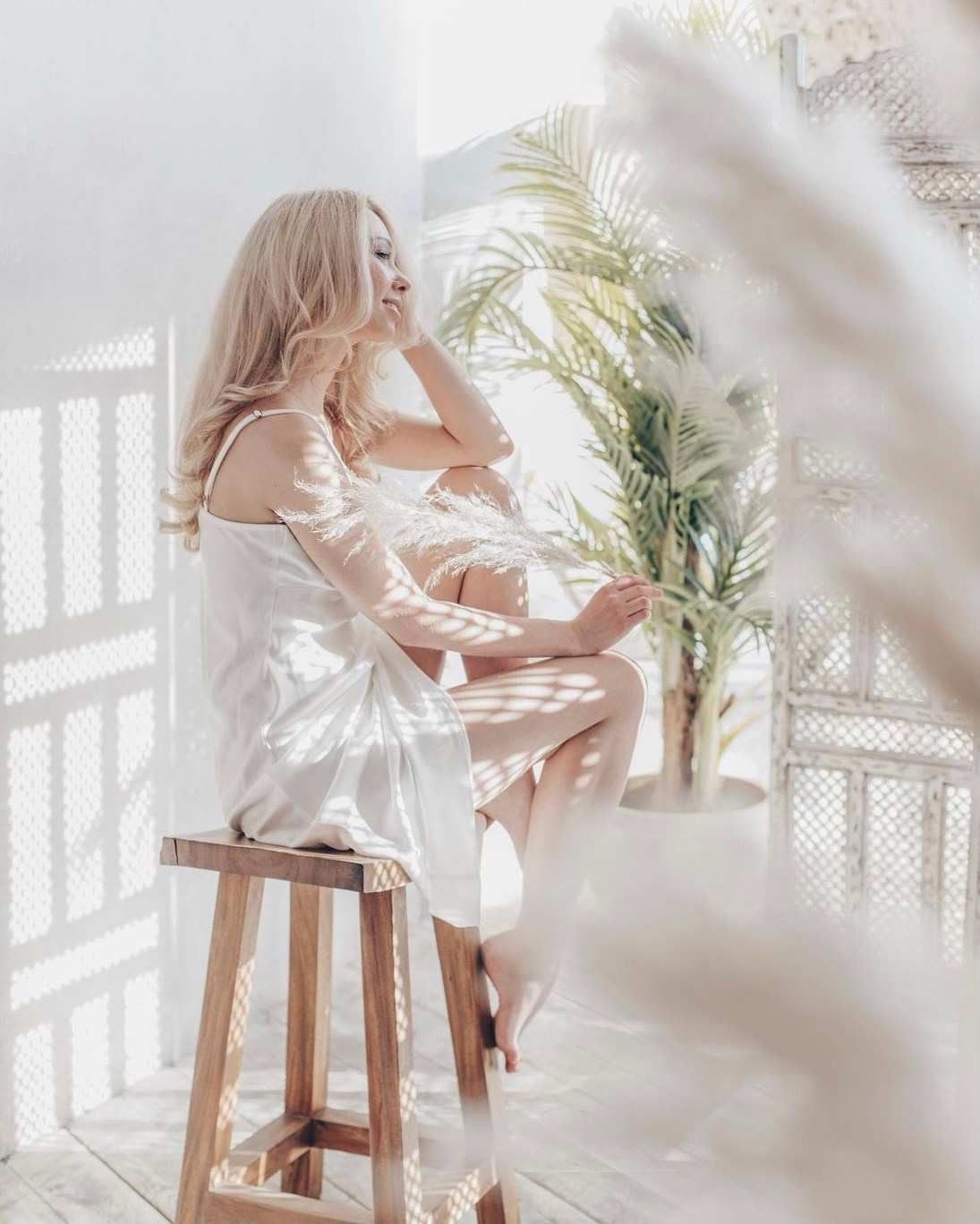 нежная девушка смотрит в окно на стуле и мечтает 