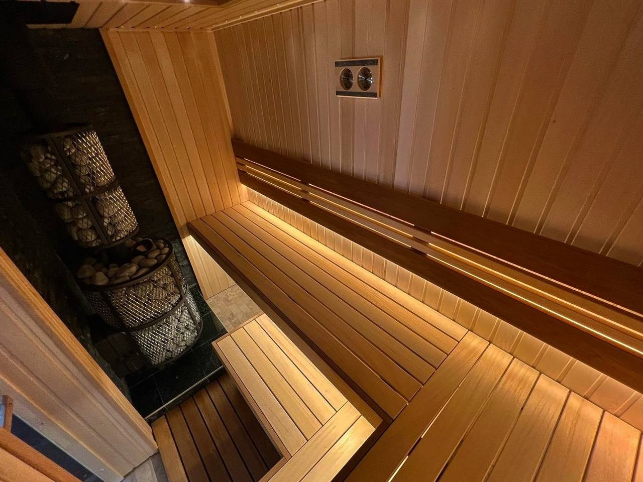 Атмосферная парная в Петергофских дачах выполнена в светлых тонах липы и абаши, с контрастной интеграцией термоабаши и тальколорита. SaunaTopMasters