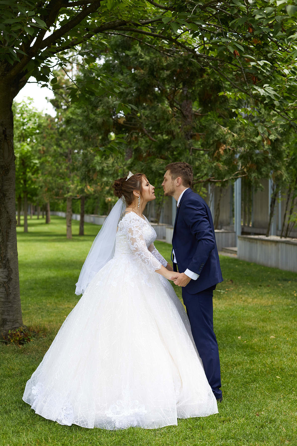 Жених и невеста держатся за руки, стоя в парке Галицкого. Свадебное фото в парке Галицкого. Фотограф. Тимашевск. Кубань. Краснодарский край.