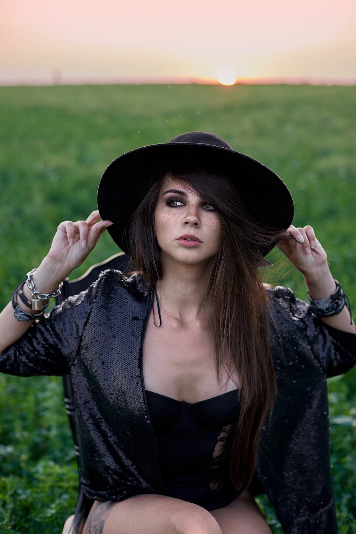 Портрет девушки в черном боди и шляпе на черном стуле в поле клевера. Фотограф. Тимашевск. Кубань. Краснодарский край.