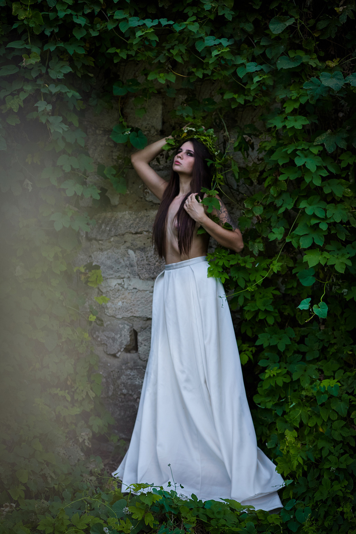Художественный портрет девушки в образе нимфы в блинной белой юбке с обнаженным торсом, длинными волосами и пышным венком из зелени. Фотограф. Тимашевск. Кубань. Краснодарский край.