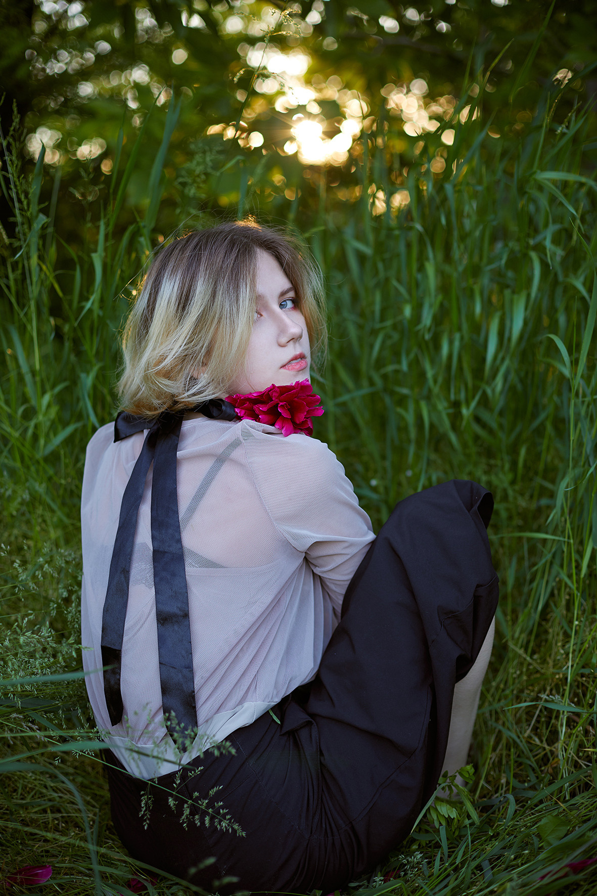 Портрет девушки в ожерелье из живых пионов на шее в лесу на закате солнца. Девушка сидит в траве. Фотограф. Тимашевск. Кубань. Краснодарский край.