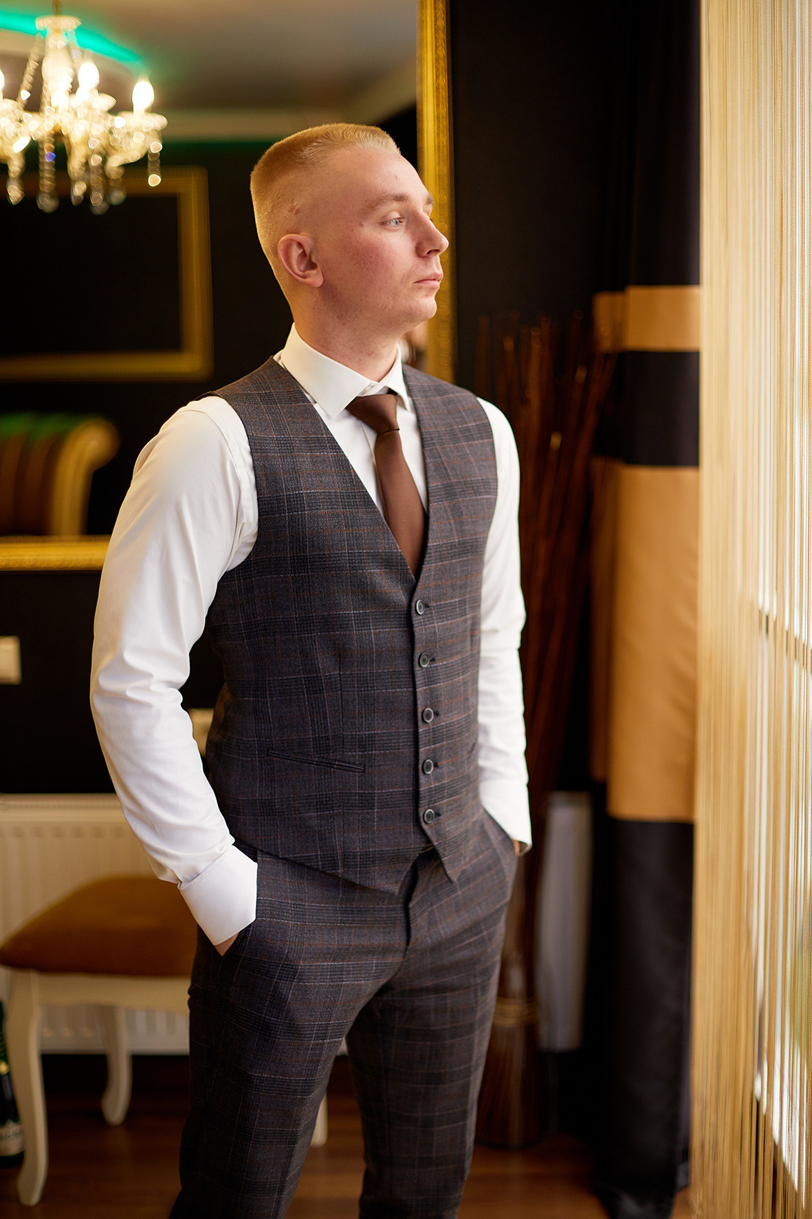Жених стоит напротив витражного окна. Фотограф. Тимашевск. Кубань. Краснодарский край. Свадебное фото в номере для новобрачных.