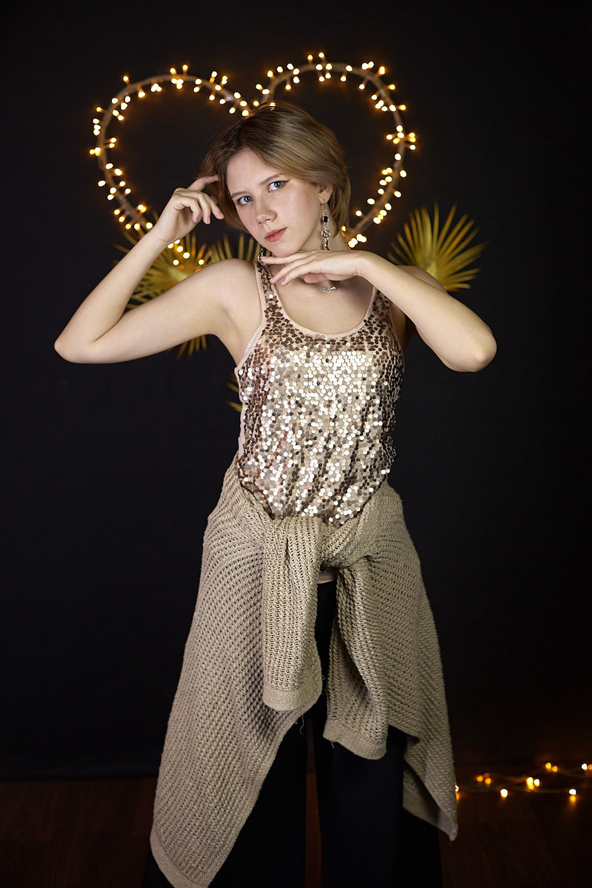 Студийный портрет молодой девушки в вязаном свитере и блестящей майке на фоне светодиодного сердца. Фотограф. Тимашевск. Кубань. Краснодарский край.