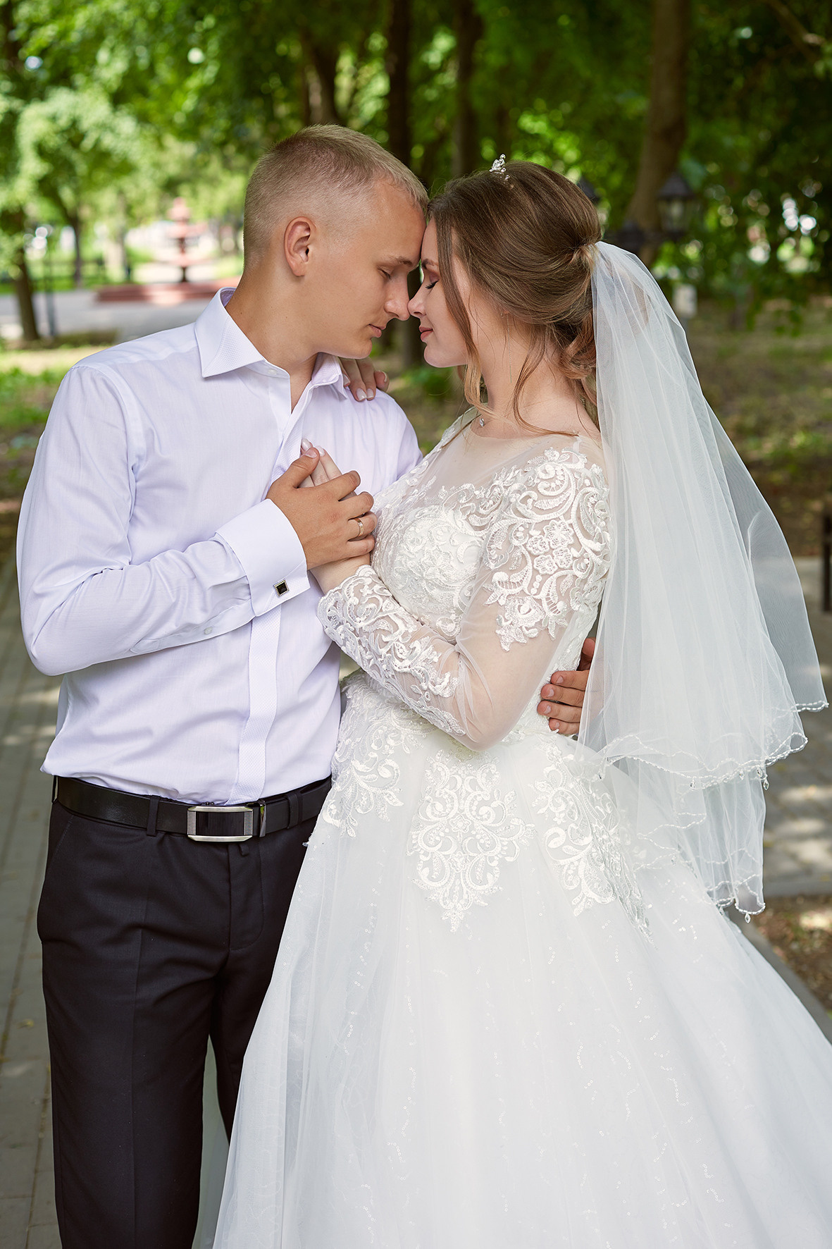 Фотография жениха и невесты в зеленом парке. Жених и невеста держатся за руки. За мгновение до поцелуя. Фотограф. Тимашевск. Кубань. Краснодарский край.