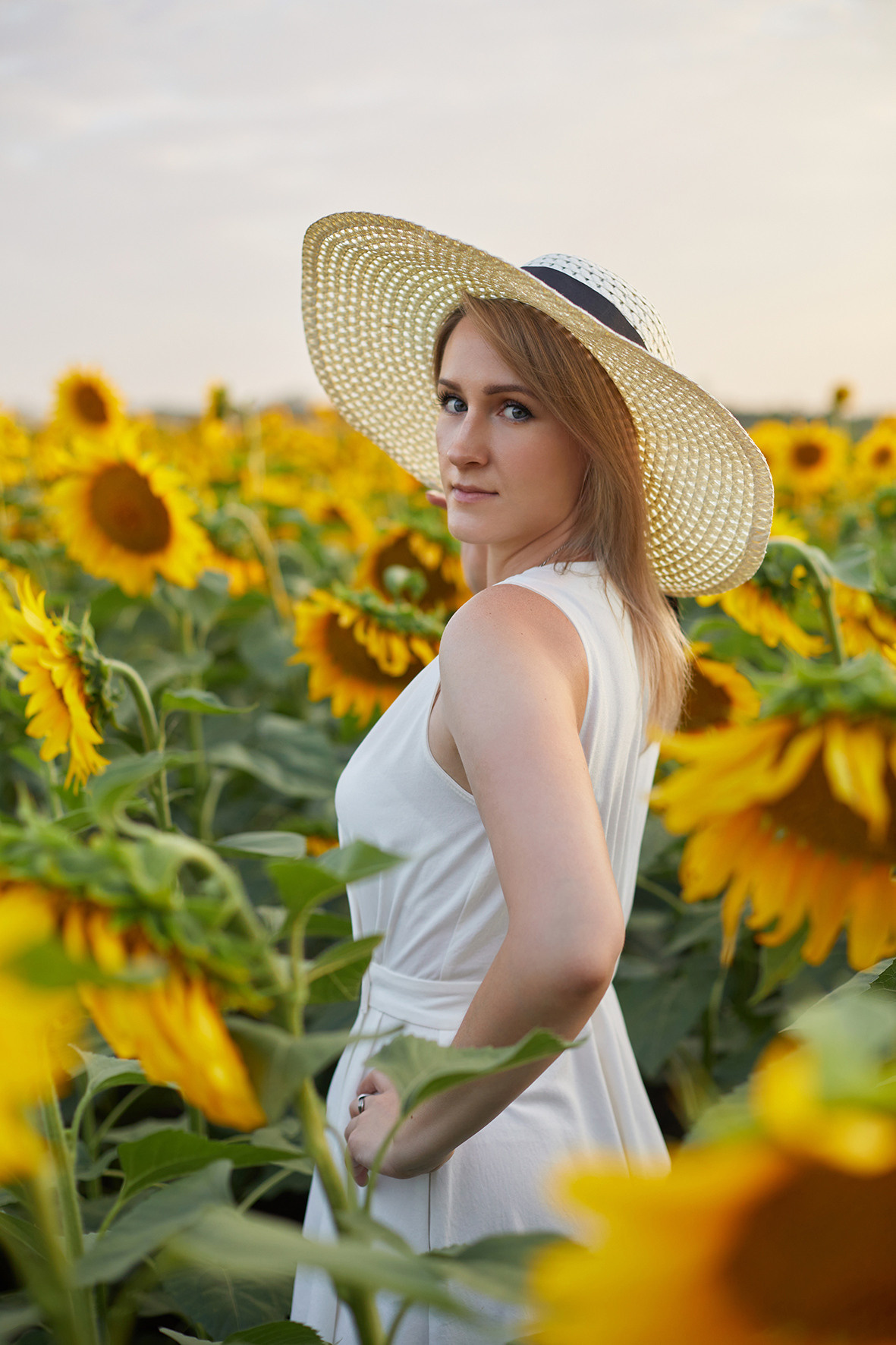 Девушка блондинка белом платье и соломенной шляпой в поле подсолнухов. Фотограф. Тимашевск. Краснодарский край.