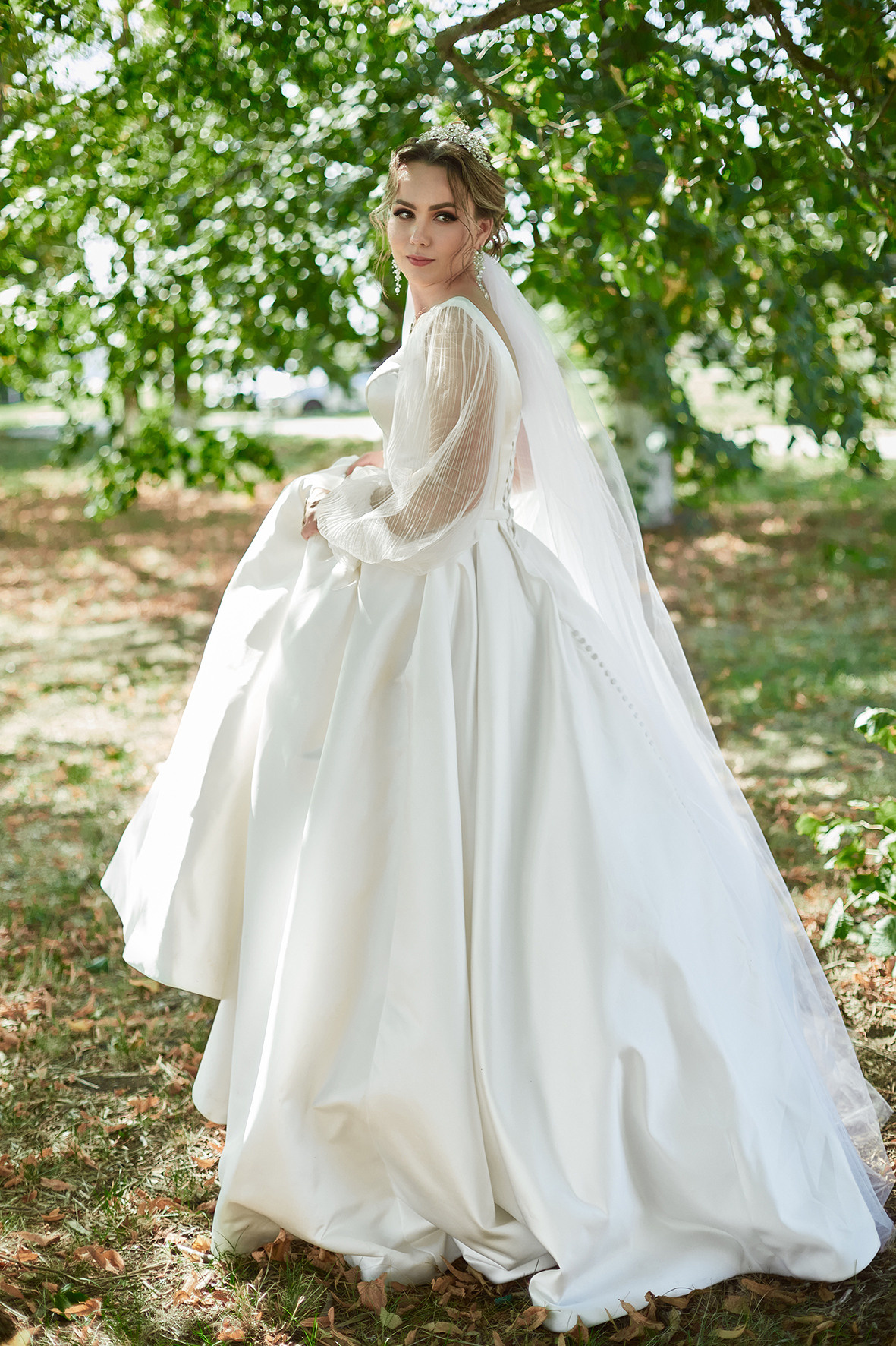 Невеста в белом платье со шлейфом идет по парку. Фотограф. Тимашевск. Кубань. Краснодарский край.