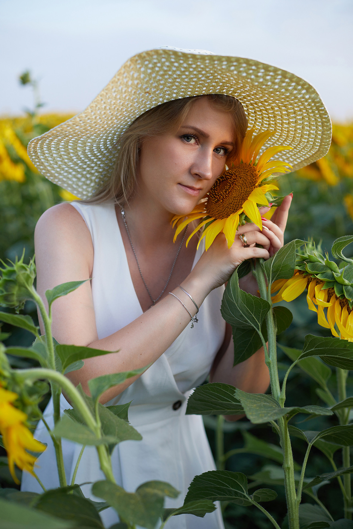 Девушка блондинка белом платье и соломенной шляпой в поле подсолнухов. Фотограф. Тимашевск. Краснодарский край.