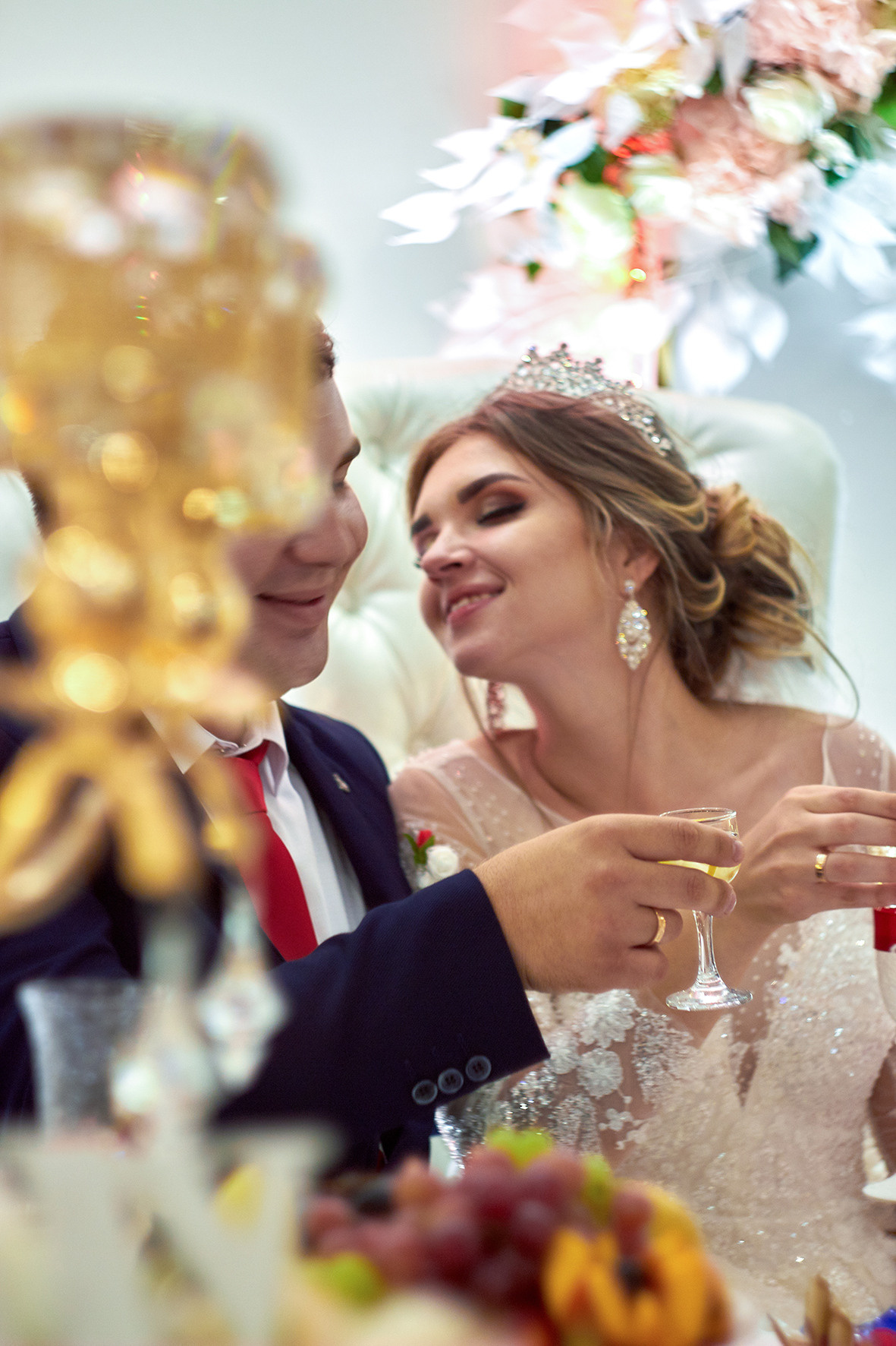 Невеста тянется к жениху за поцелуем. Свадебный вечер в кафе. Президиум для молодоженов. Бокалы в руках жениха и невесты. Шампанское. Портрет невесты на природе. Диадема. Корона. Фотограф. Тимашевск. Кубань. Краснодарский край.