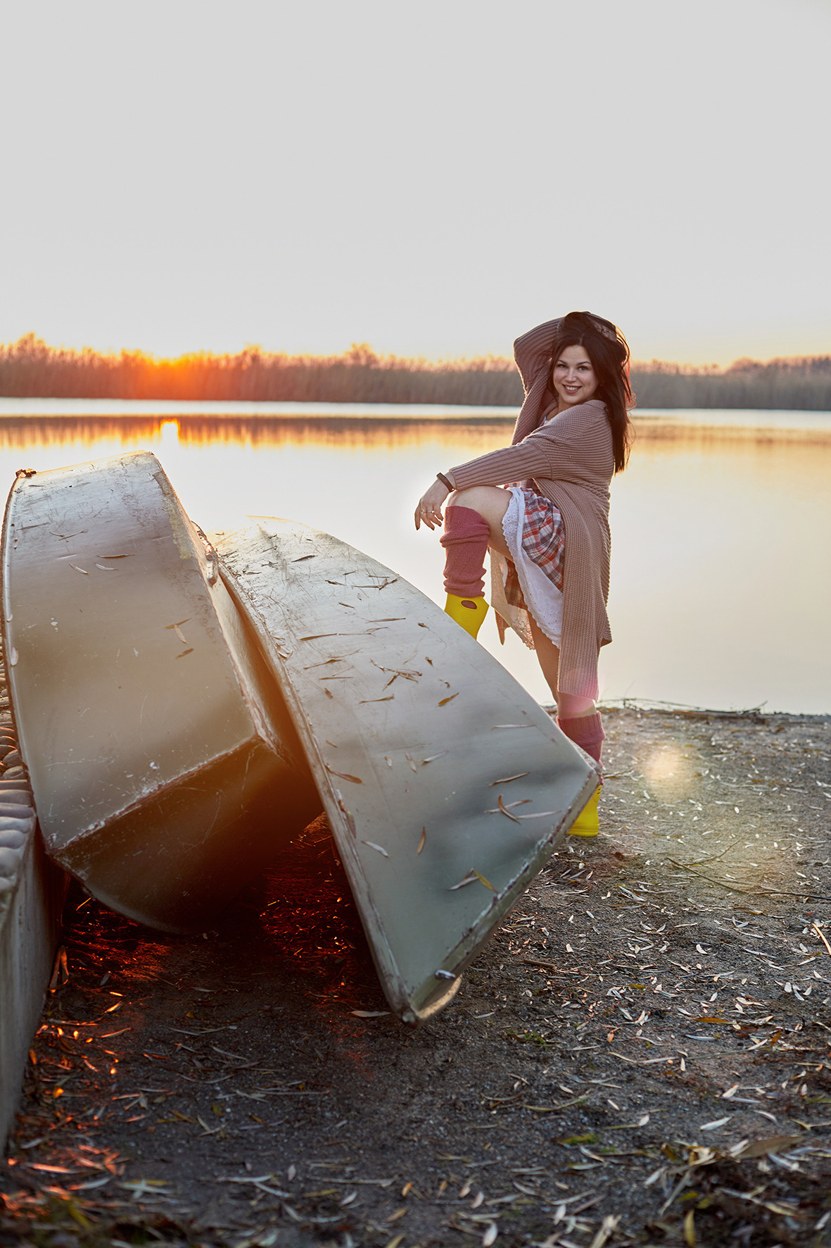 Портрет девушки на реке на закате. Девушка в вязаном кардигане и желтых резиновых сапожках на берегу реки возле лодки. Фотограф. Тимашевск. Кубань. Краснодарский край. 