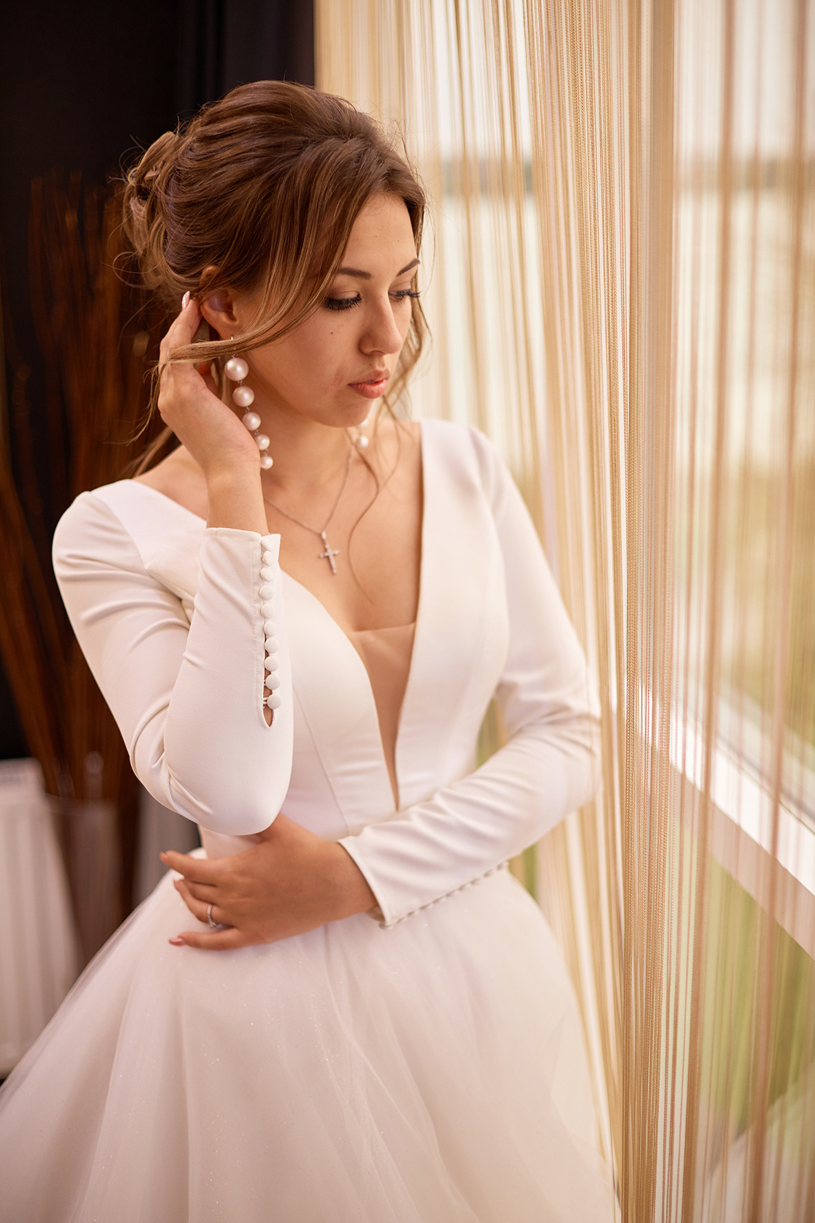 Невеста стоит у витражного окна. Фотограф. Тимашевск. Кубань. Краснодарский край. Свадебное фото в номере для новобрачных.