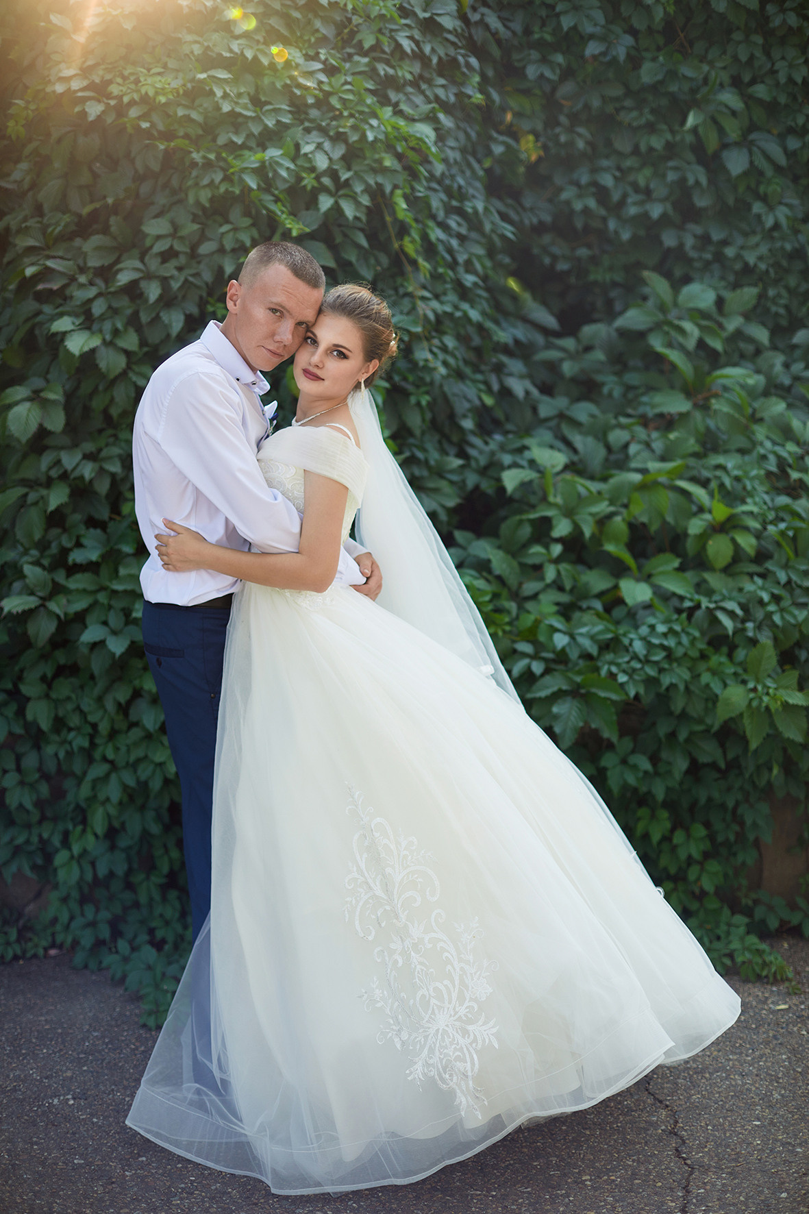 Невеста и жених обнимаются на фоне зеленой листвы. Фотограф. Кубань. Краснодарский край. Тимашевск.