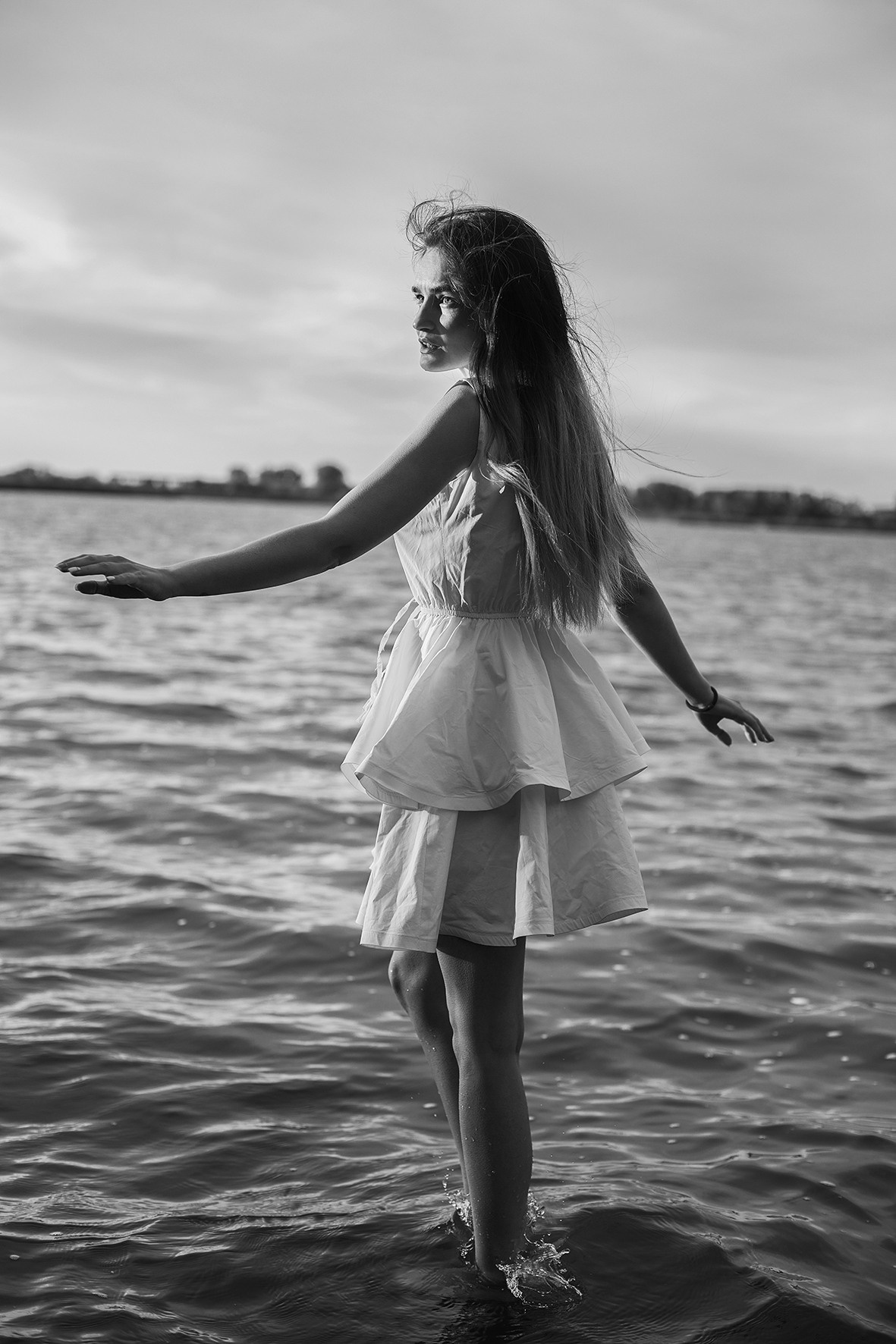 Девушка в белом коротком платье идет по воде. Река. Ветер развевает волосы. Фотограф. Тимашевск. Кубань. Краснодарский край.