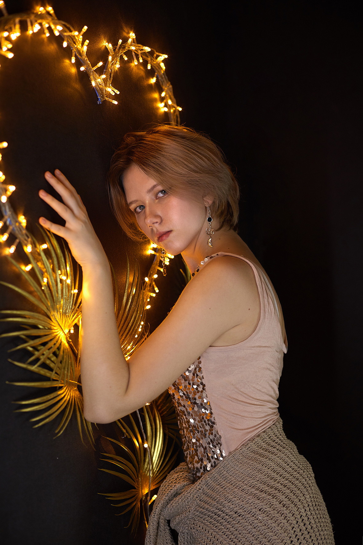 Студийный портрет молодой девушки в вязаном свитере и блестящей майке на фоне светодиодного сердца. Фотограф. Тимашевск. Кубань. Краснодарский край.