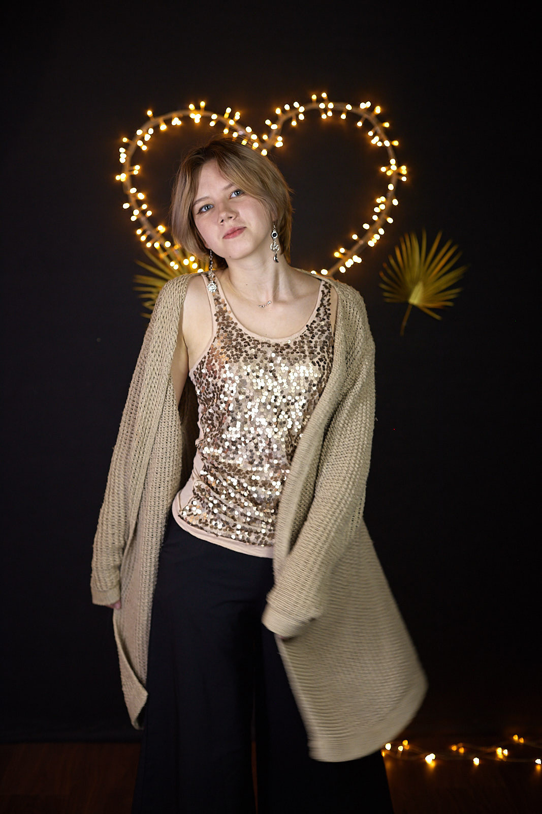 Студийный портрет молодой девушки в вязаном свитере и блестящей майке на фоне светодиодного сердца. Фотограф. Тимашевск. Кубань. Краснодарский край.