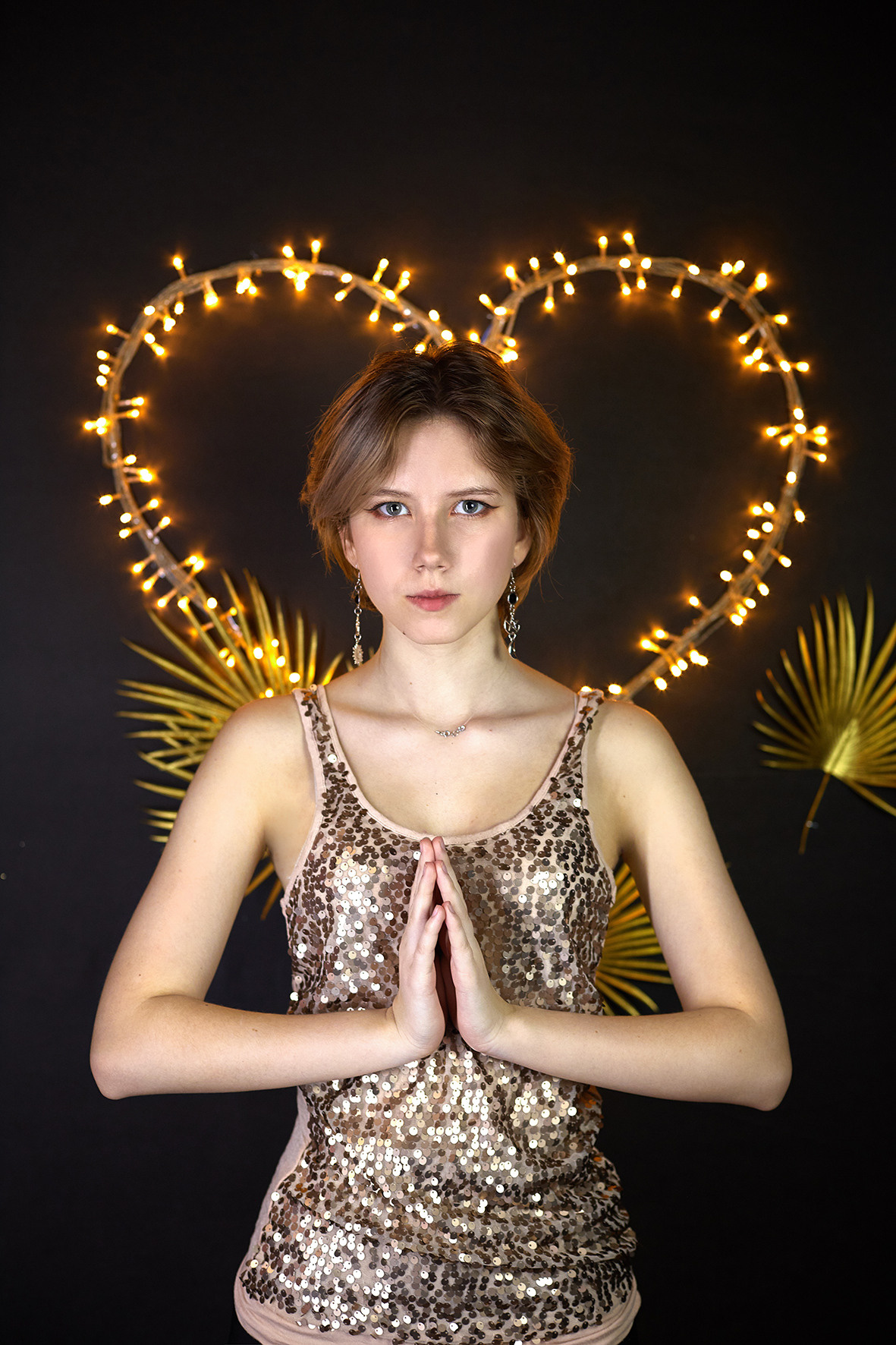 Студийный портрет молодой девушки в вязаном свитере и блестящей майке на фоне светодиодного сердца. Фотограф. Тимашевск. Кубань. Краснодарский край.