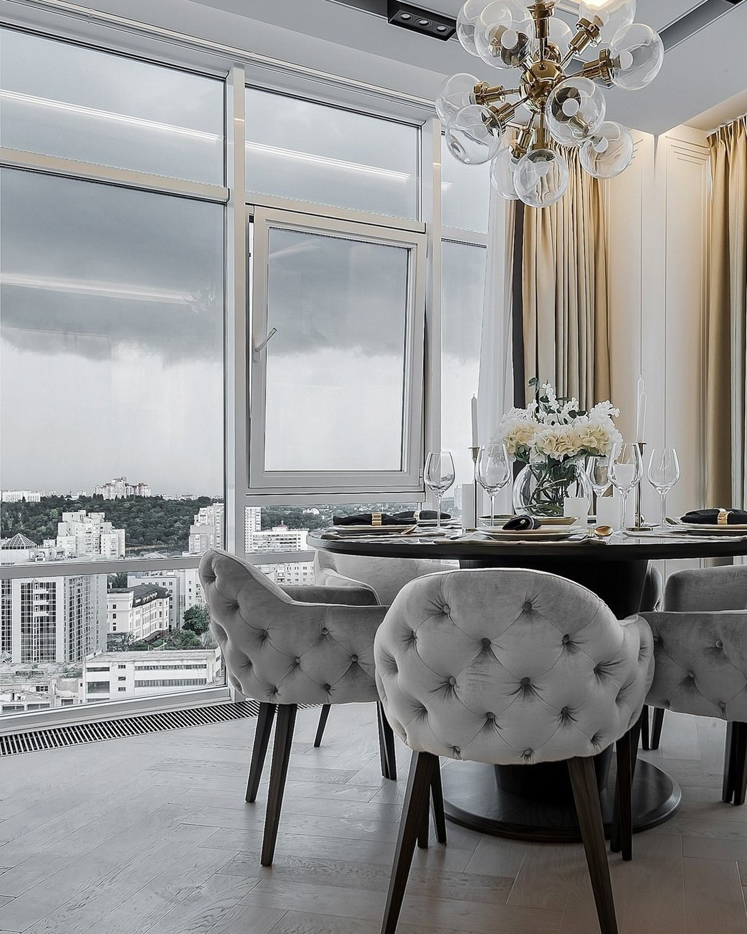 Круглый стол с бархатными креслами у окна с видом на город | Валерия Котович