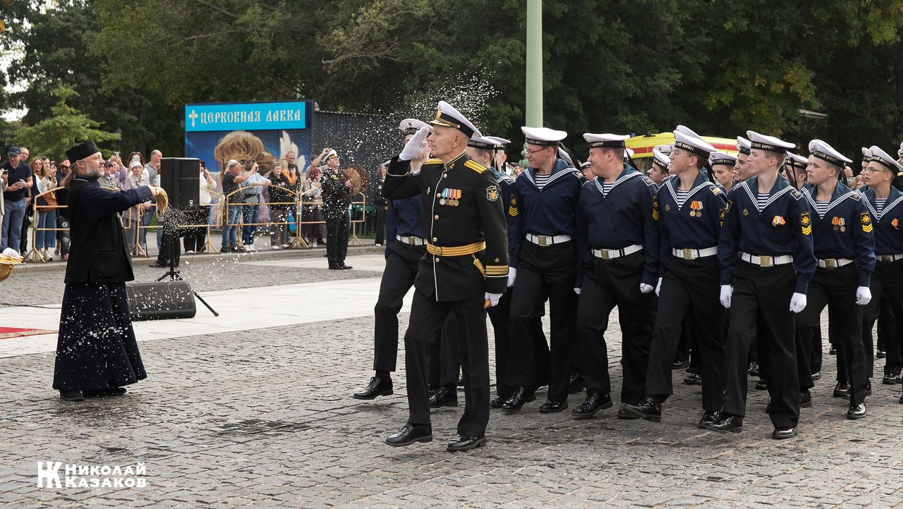 Священик благословляет святой водой кадетов  морского кадетского военного корпуса во время марша  по Якорной площади 