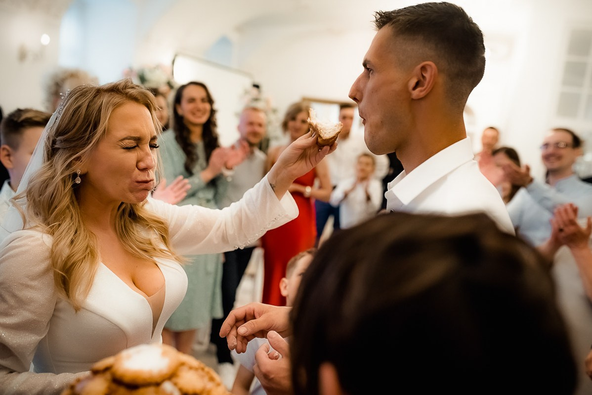 Жених и невеста скормят друг друга хлебом в ресторане в Санкт-Петербурге.  Горизонтальный  поясной кадр.