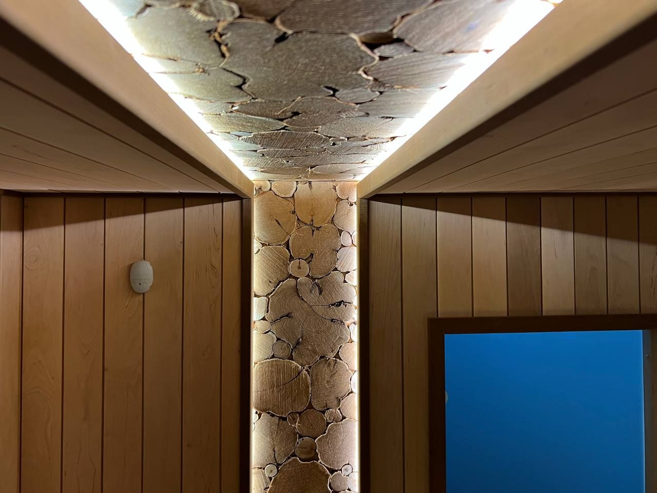 Просторная сауна в Сертолово из термоольхи с интеграцией можжевеловых линий и большого количества натурального камня. SaunaTopMasters