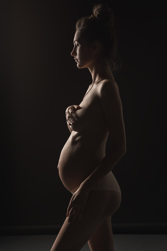 фотосъемка обнаженной беременной женщины, фотосессия в стиле минимализм в фотостудии на фонах в темном ключе, фотография беременной женщины