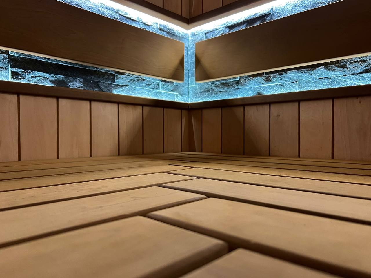 Просторная сауна в Сертолово из термоольхи с интеграцией можжевеловых линий и большого количества натурального камня. SaunaTopMasters