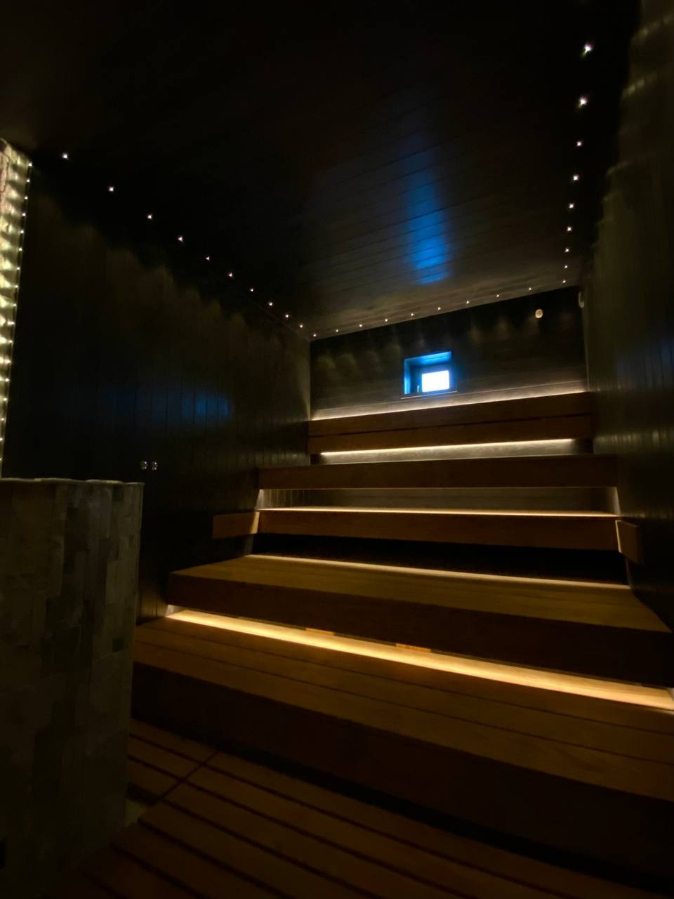 Чёрная «Богатырь-баня» в Боровске: четыре уровня полков, белый кварцит в противопожарном углу и кастомная газовая печь в центре внимания. SaunaTopMasters