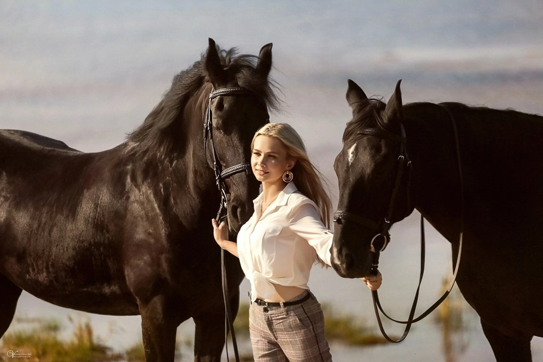 Девушка и два вороных коня на берегу моря