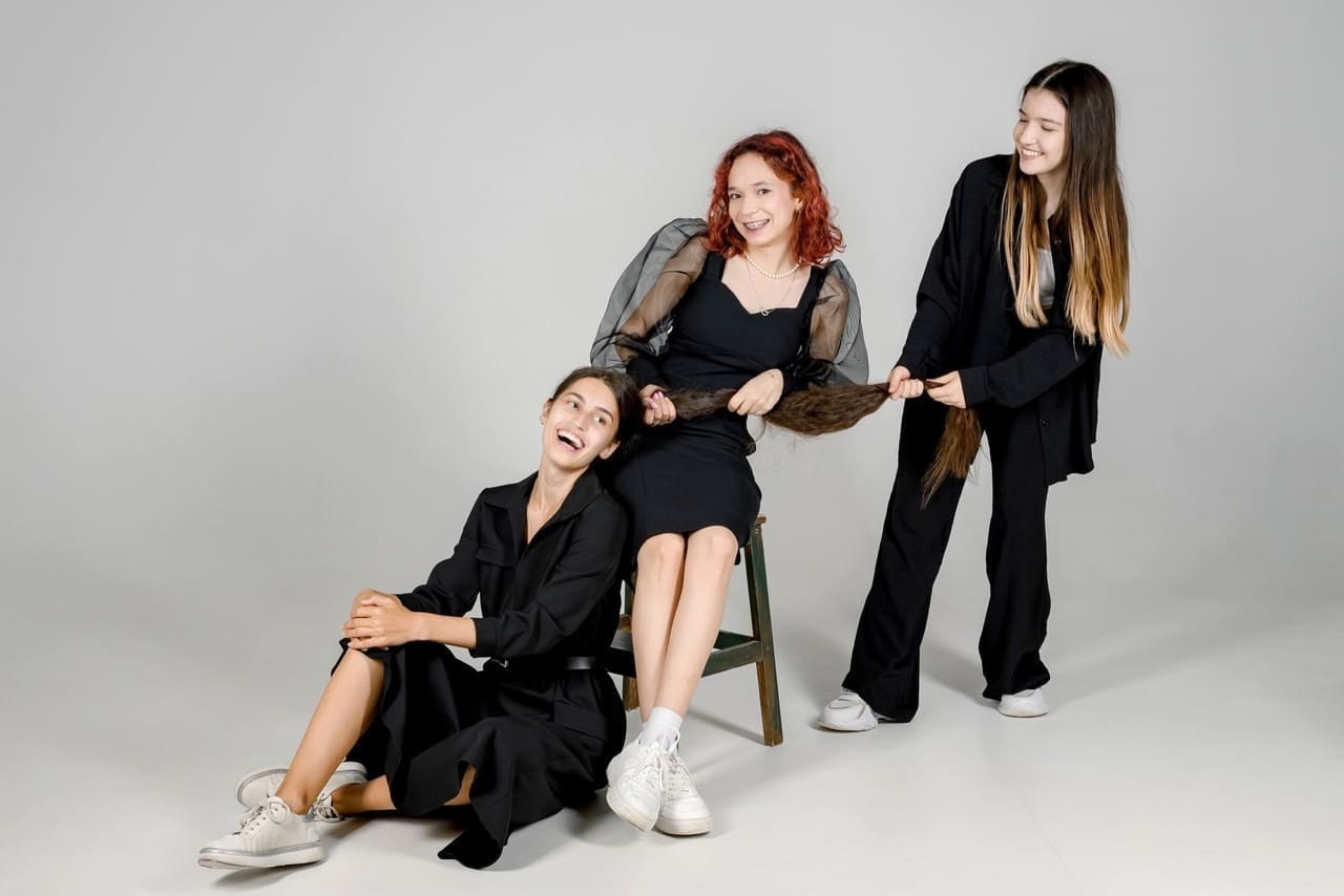 Девочки тянут одноклассницу за хвост для эффекта сногсшибательного фото.