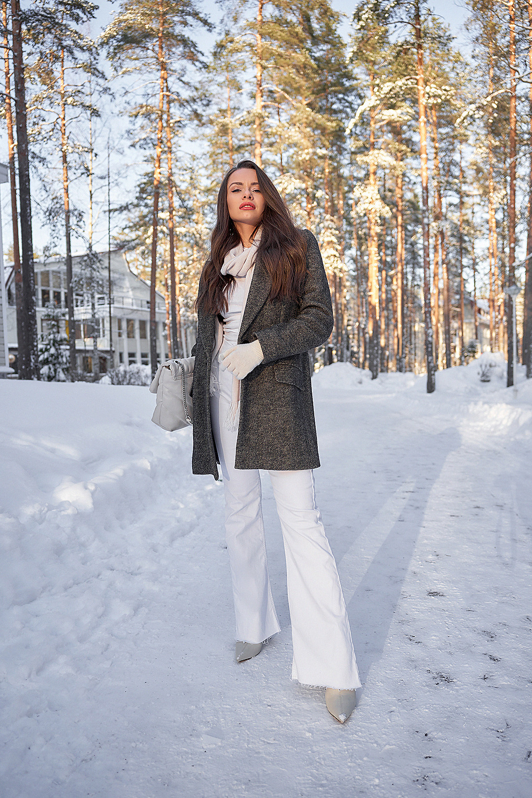 Фэшн портрет девушки в пальто в снежном лесу на закате