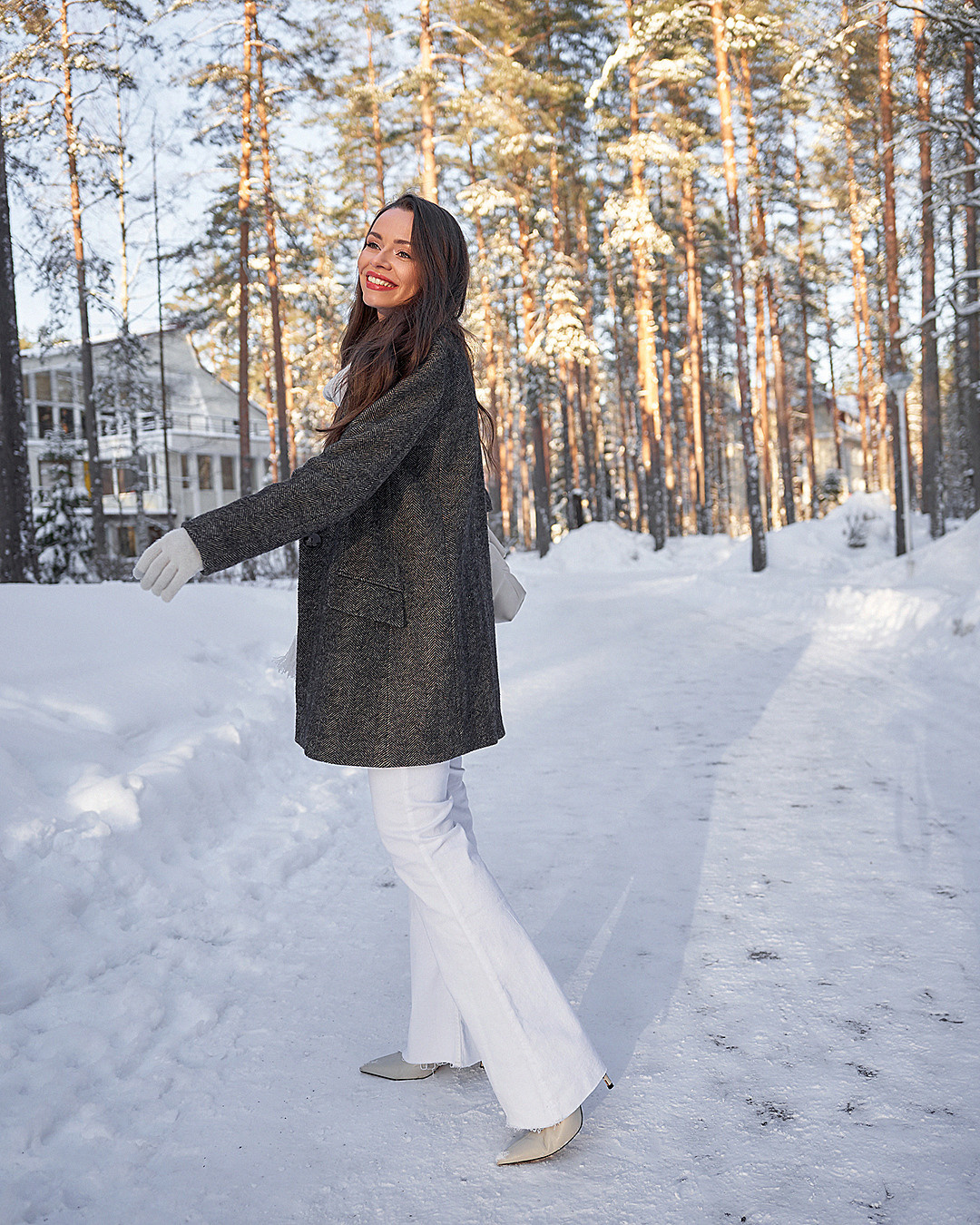 Фэшн портрет девушки в пальто в снежном лесу на закате