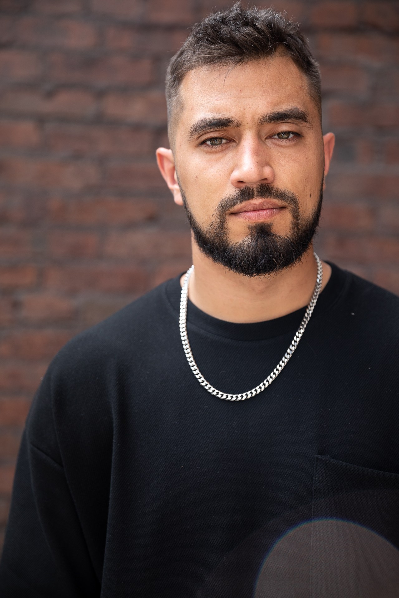 Смуглый мужчина с бородой в черной футболке