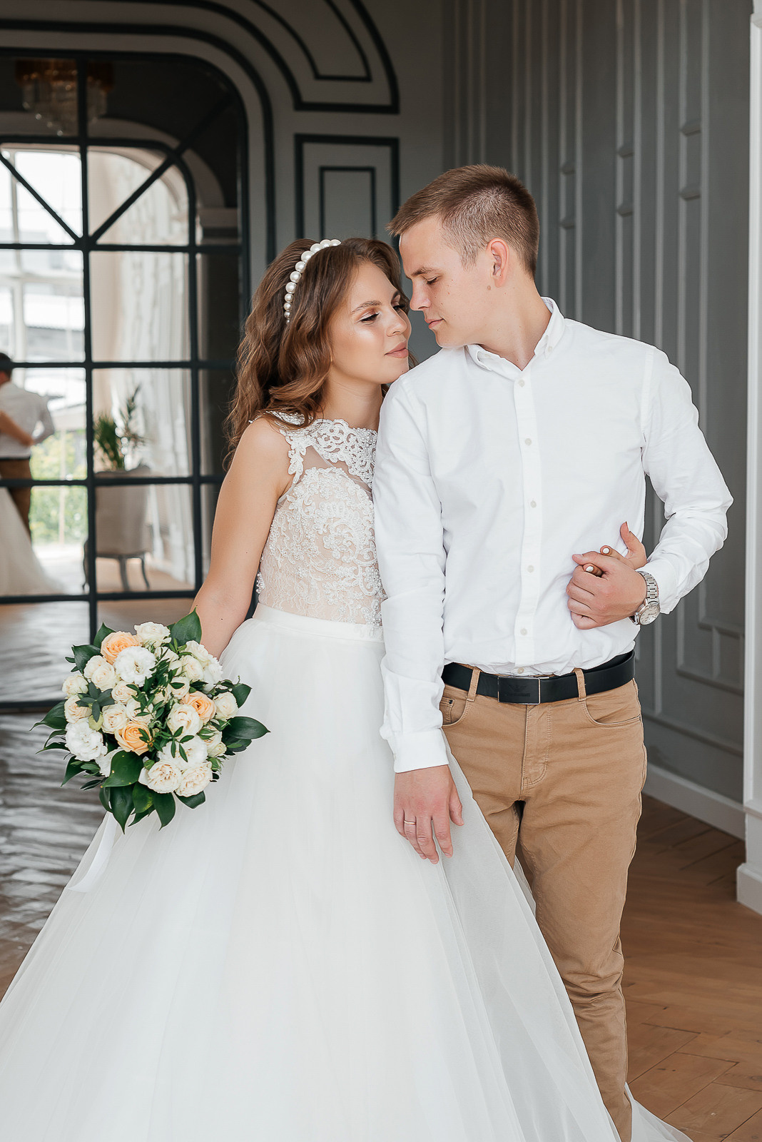 жених и невеста с букетом цветов в фотостудии 