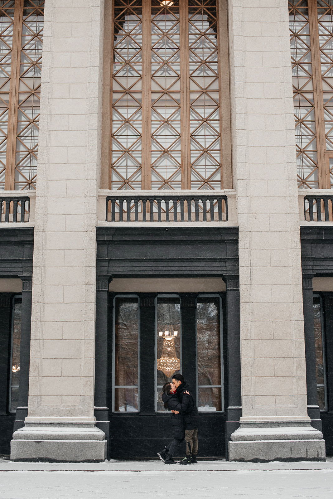 пара целуется на фоне архитектуры