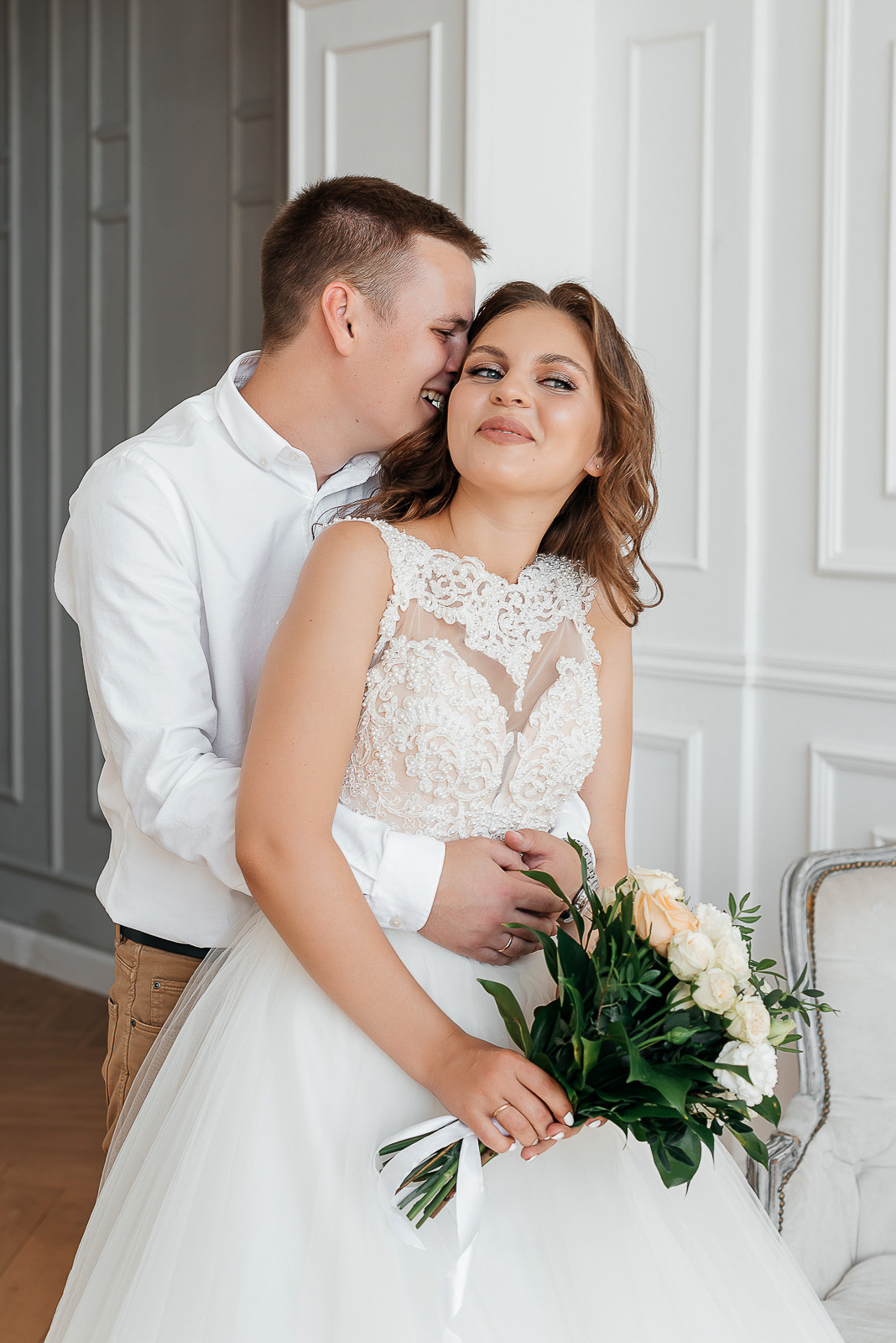 жених и невеста с букетом цветов в фотостудии 