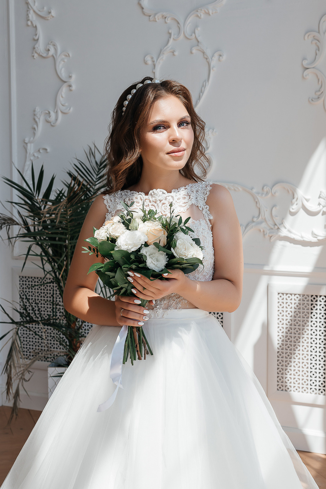 невеста с букетом цветов в светлой фотостудии
