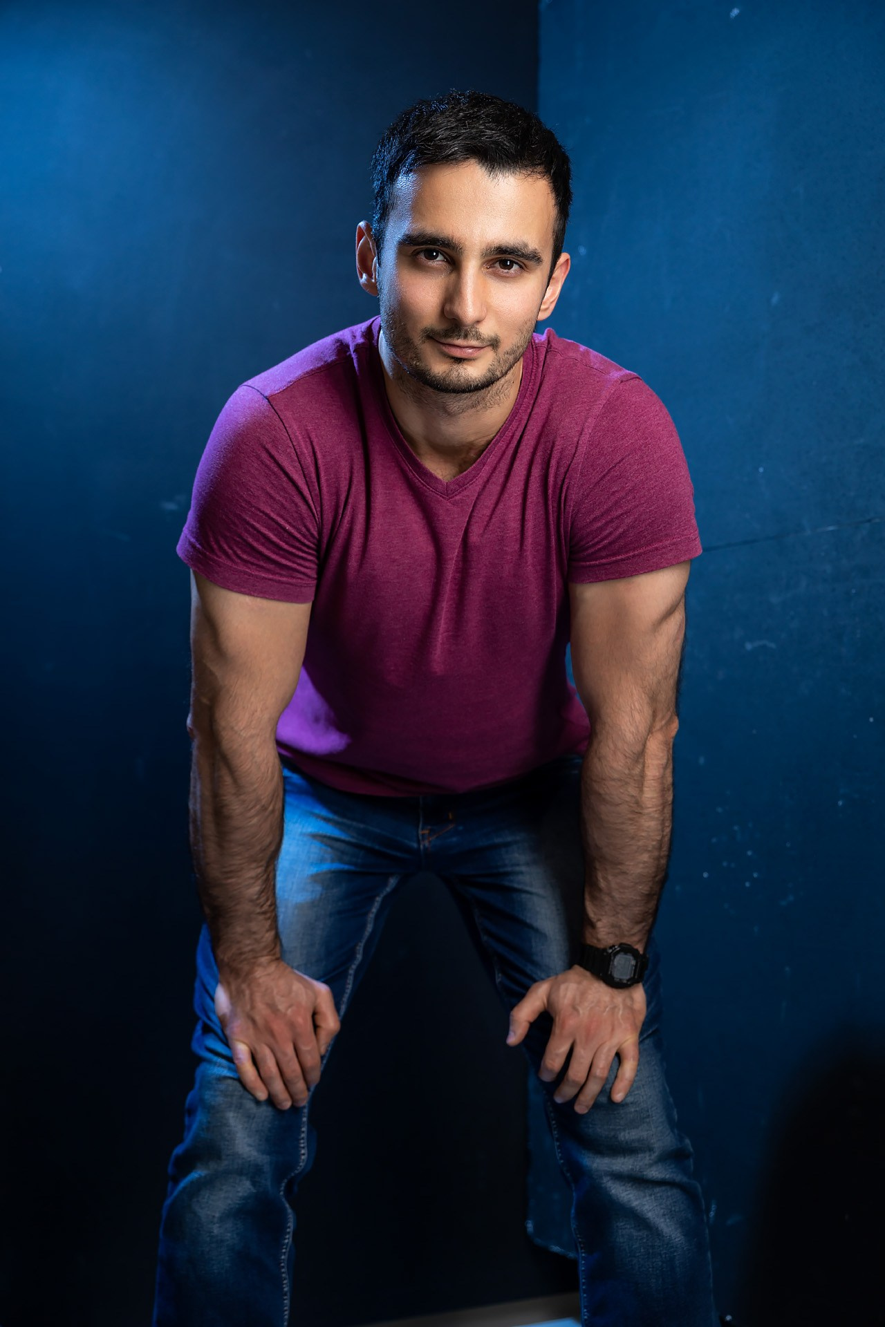 Мужчина позирует в студии на темном фоне