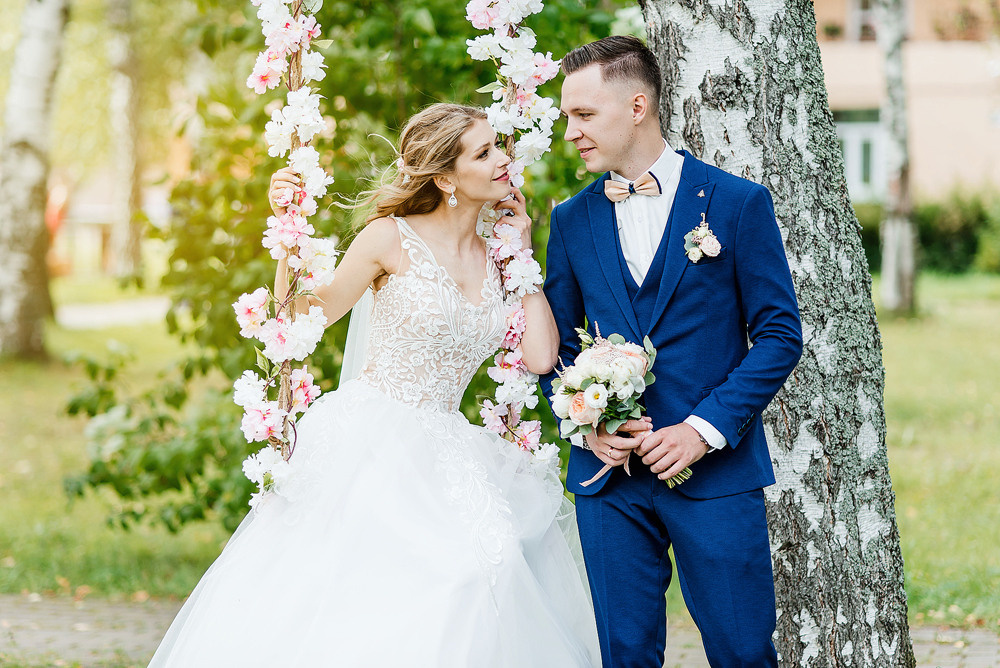 Невеста на качели в летнюю свадьбу с женихом